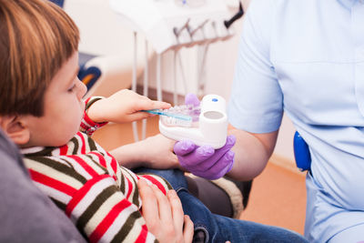 Child brushing teeth model at dental clinic