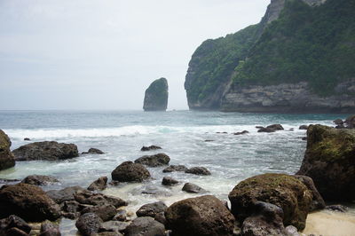 Scenic view of sea by cliff against sky