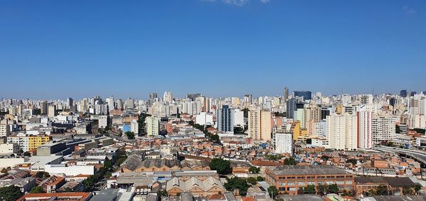 High angle view of buildings against clear blue sky