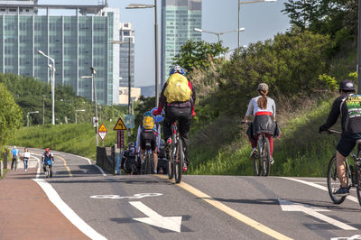 People riding bicycles on road in city