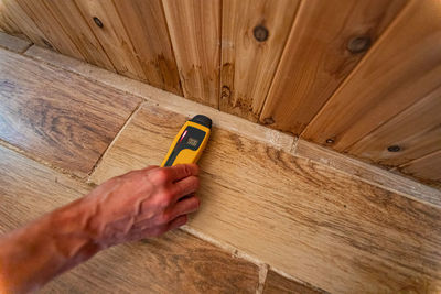 High angle view of person hand on wooden floor