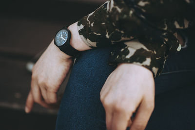 High angle view of man hand holding clock