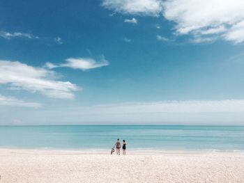 Two people standing on idyllic sandy beach