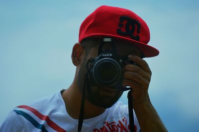 Close-up of man photographing against clear sky