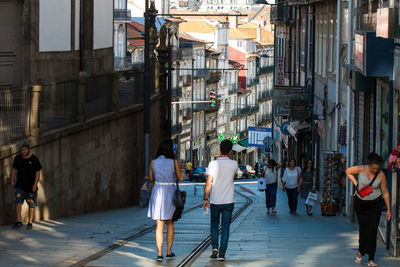 People walking on street amidst buildings in city