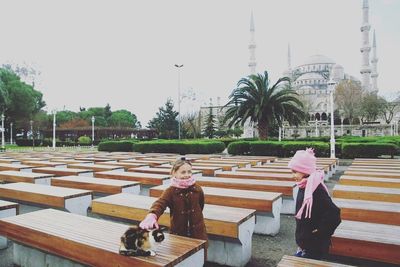 People sitting on bench against building