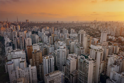 Aerial view of cityscape against sky during sunset