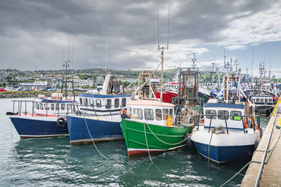 Four small fishing boats moored in howth harbour, dublin, ireland