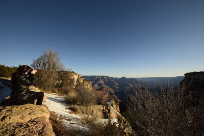 Man on rock against sky