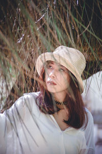 Woman looking away by plants outdoors