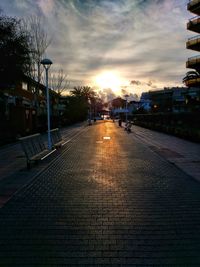 Road in city against sky at sunset