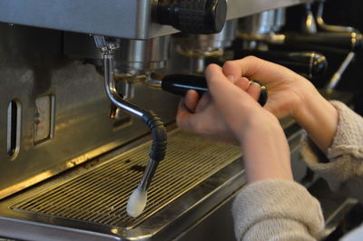 Cropped image of barista using espresso maker in cafe