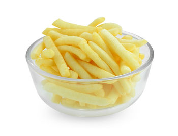 Close-up of fries and yellow bowl on white background