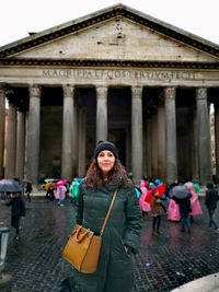 Portrait of woman wearing warm clothing standing in city