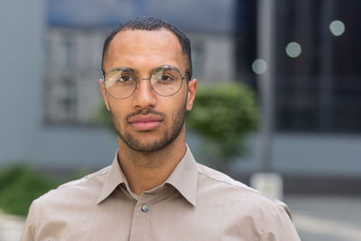 Portrait of young man standing in city