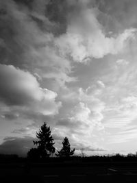 Low angle view of storm clouds over silhouette landscape