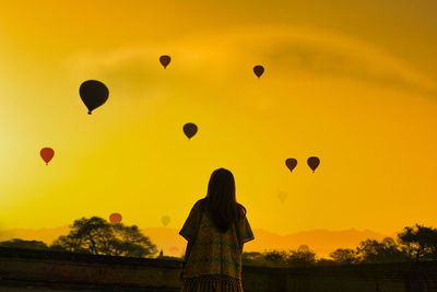 Silhouette of hot air balloons against sky during sunset