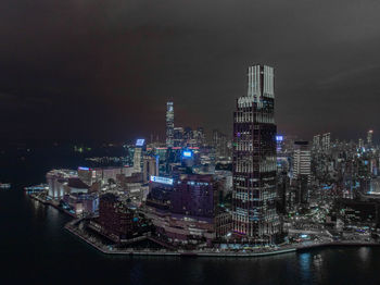 Illuminated buildings in city against sky at night