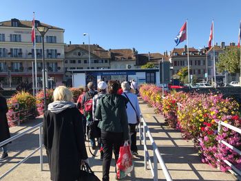 Rear view of people walking on street in city