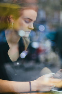 Young woman looking at mobile phone in cafe