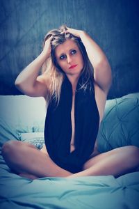 Portrait of beautiful woman lying on bed at home