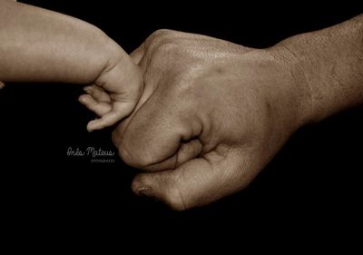 Close-up of hands against black background