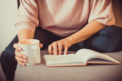 Midsection of man reading book