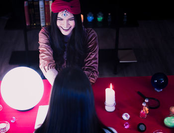 Portrait of a smiling young woman sitting on table