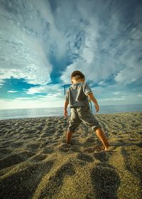 Full length of little boy playing on beach