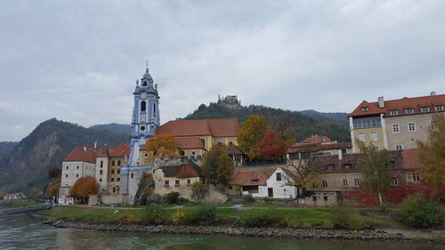 Houses and buildings in city against sky