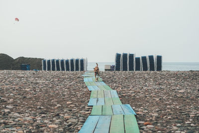 Woman standing on beach against clear sky