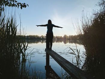 Reflection of man in lake against sky