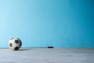Close-up of soccer ball on floor against wall