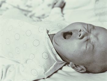 Close-up of baby girl sleeping on bed