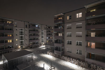 Courtyard of a residential district at nighttime in winter with illuminated windows in munich