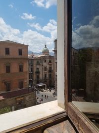 Buildings in city against cloudy sky