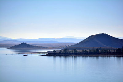 Scenic view of lake and mountains against clear sky