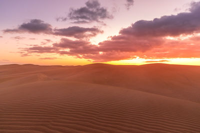 Scenic view of desert against sky during sunset