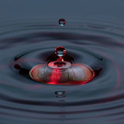 Close-up of drop splashing in water on euro coin