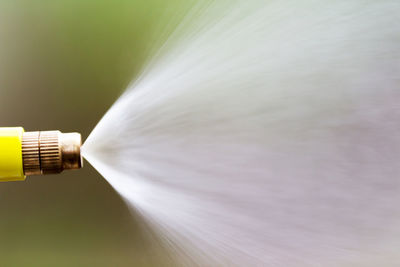 Close-up of sprinkler against grass