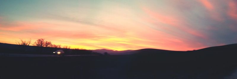 Scenic view of silhouette mountains against sky at sunset