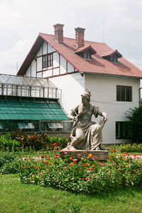 Statue of flowering plant against building