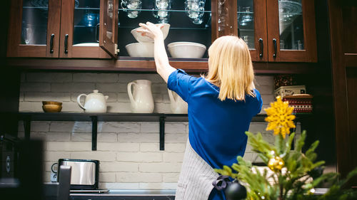 Rear view of woman preparing food in kitchen