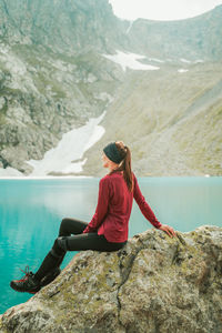 Woman sitting on rock looking at mountain