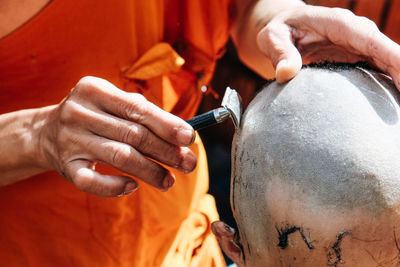 Close-up of man shaving head of boy