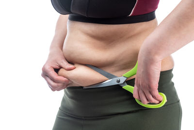 Midsection of woman standing against white background