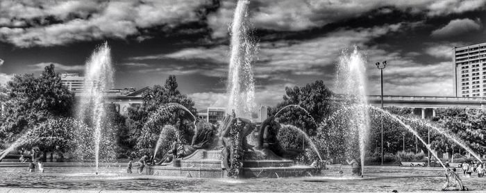 Fountain against cloudy sky