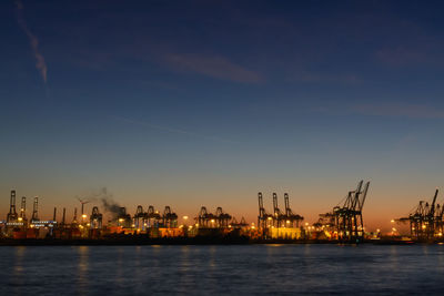 Commercial dock by sea against sky at night