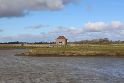 House on land by building against sky