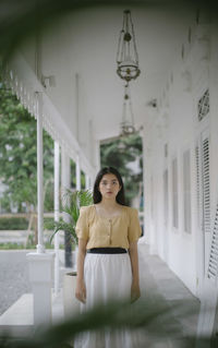 Portrait of young woman standing in corridor